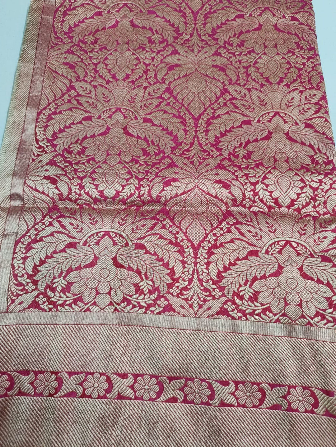 Textured fabric with pink and beige floral patterns on a light blue background
