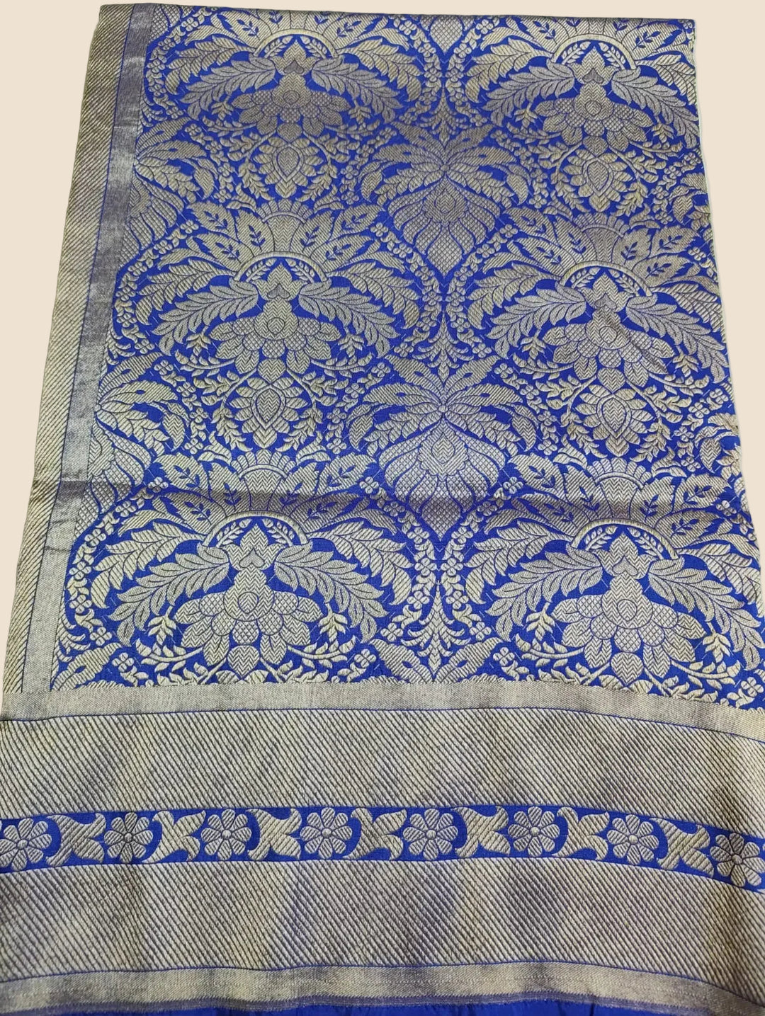 Decorative fabric with blue and silver floral patterns on a white background