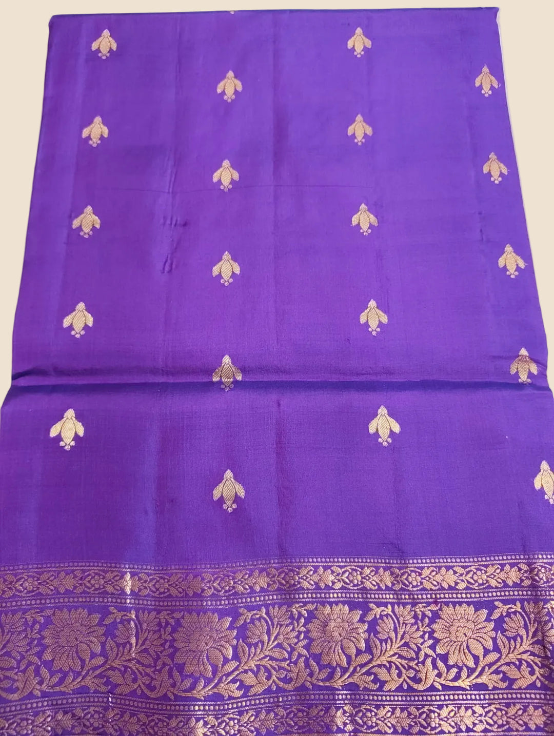 Purple fabric with gold floral patterns on a white background
