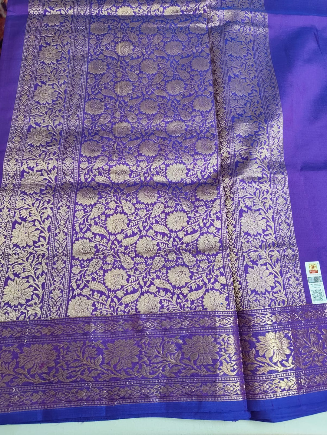 Purple fabric with intricate gold patterns on a white background