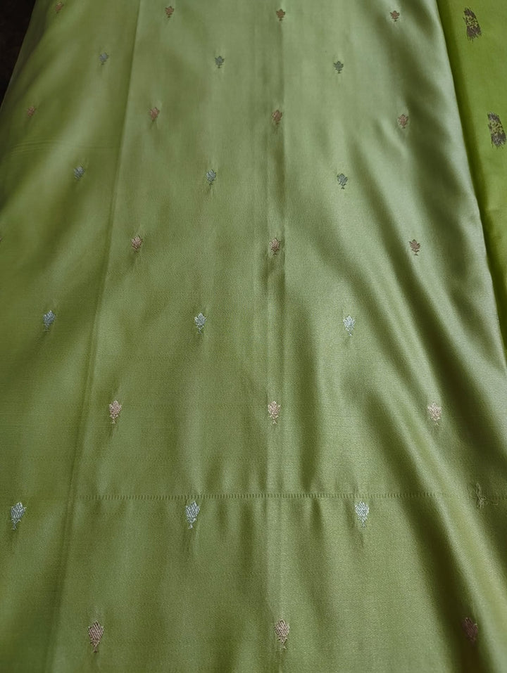 Close-up of green fabric with small embroidered patterns