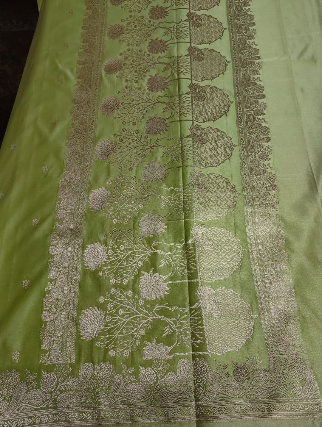 Green fabric with intricate white floral patterns