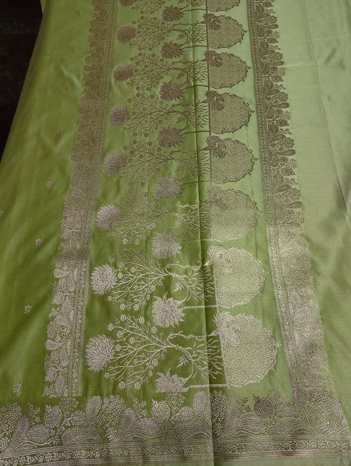 Green fabric with intricate white floral patterns