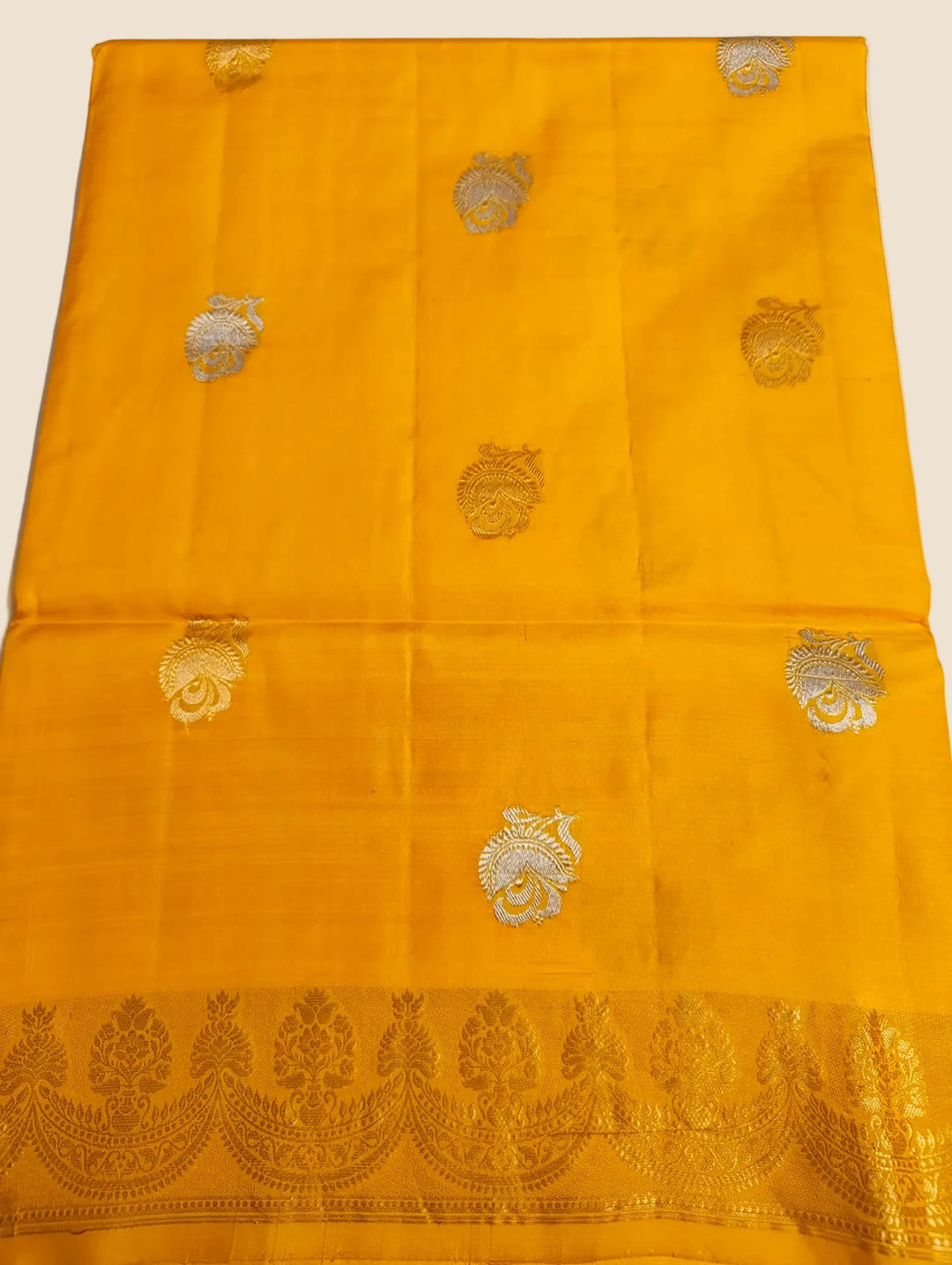 Yellow fabric with gold embroidery on a white background