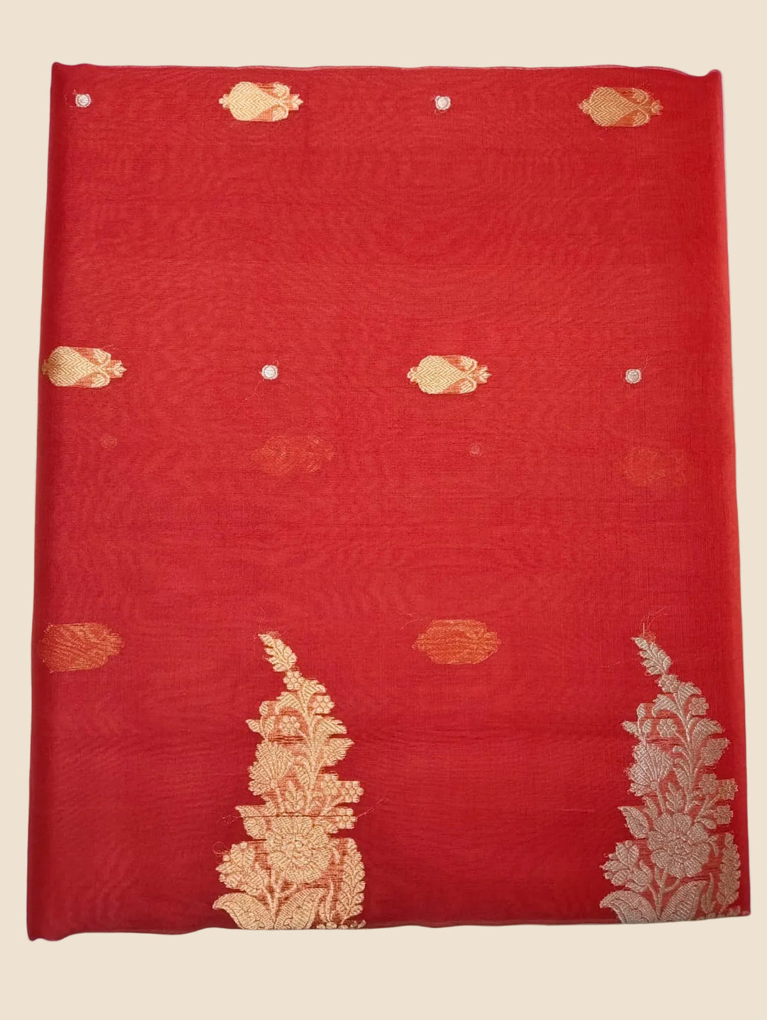 Red fabric with gold embroidery on a white background