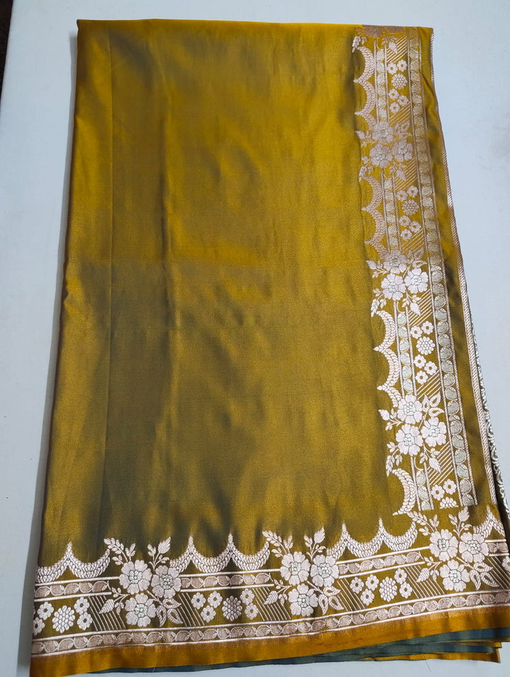 Mustard yellow fabric with white floral embroidery on a plain background
