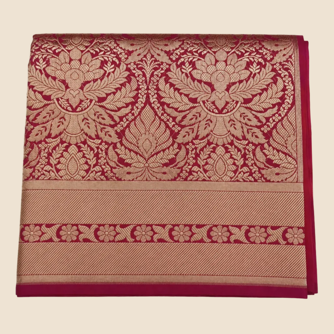 Folded fabric with intricate red and gold pattern on a white background