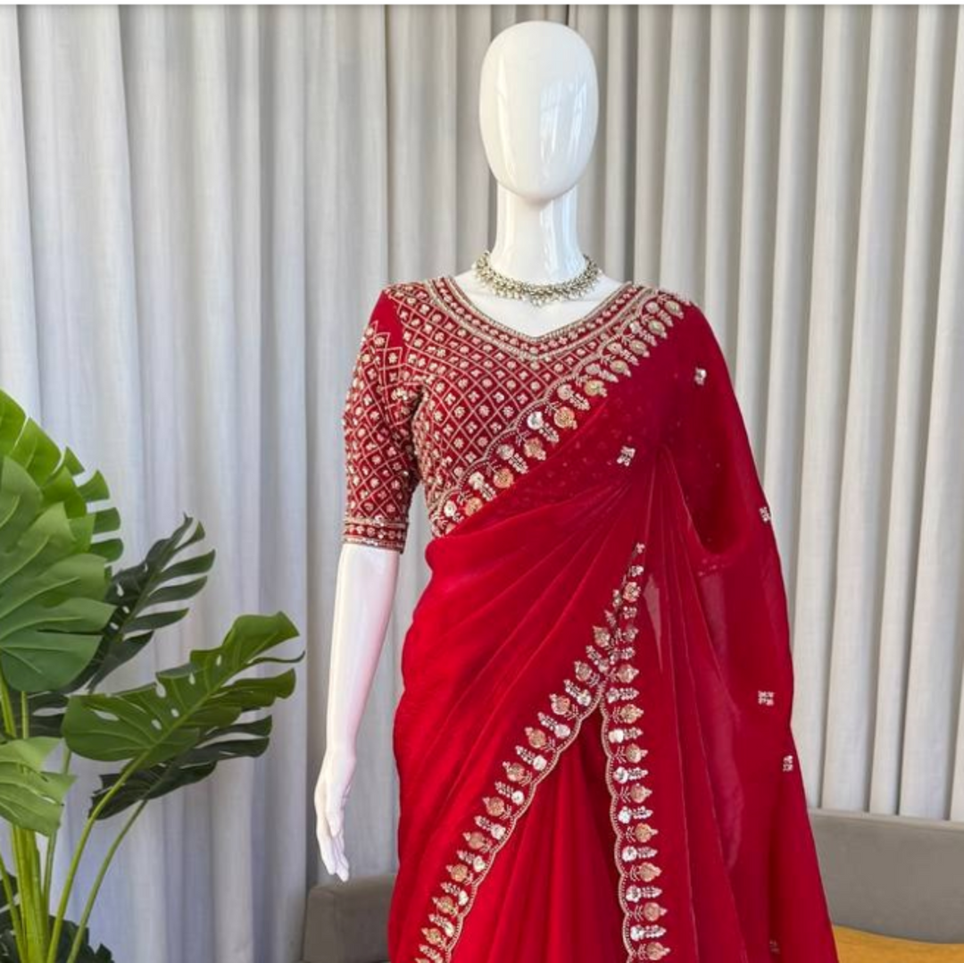 Red saree with gold embroidery on a mannequin against a neutral background