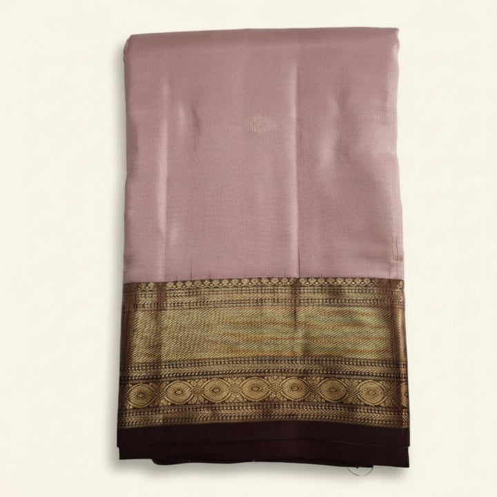 Pink saree with a brown and gold border on a white background