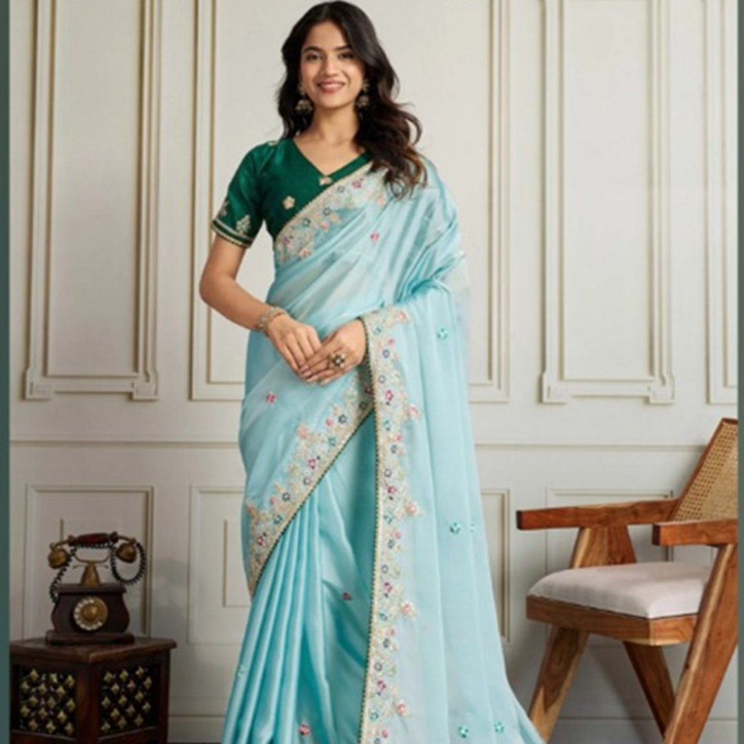 Woman wearing a light blue saree with a green blouse